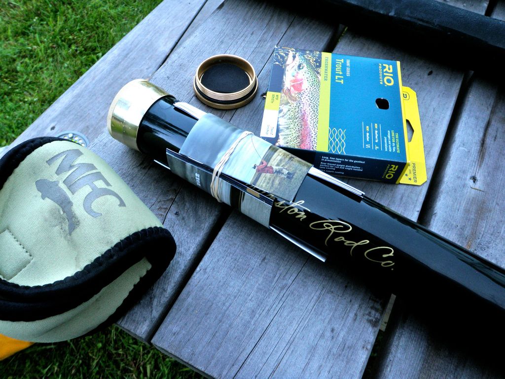 Fly rod, reel, line and tackle arranged on a wooden table