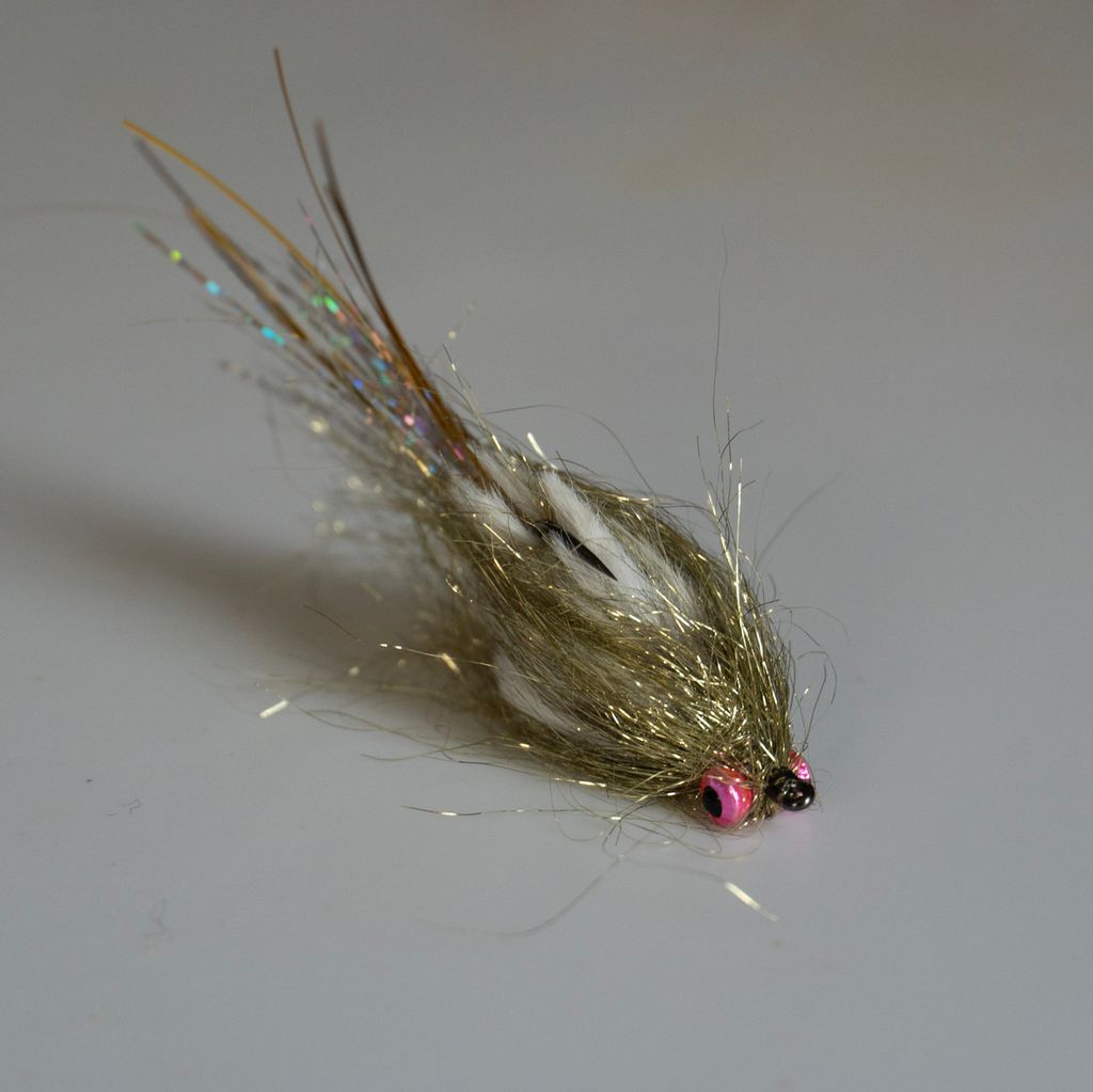 Olive streamer fly with a pink head on a plain background