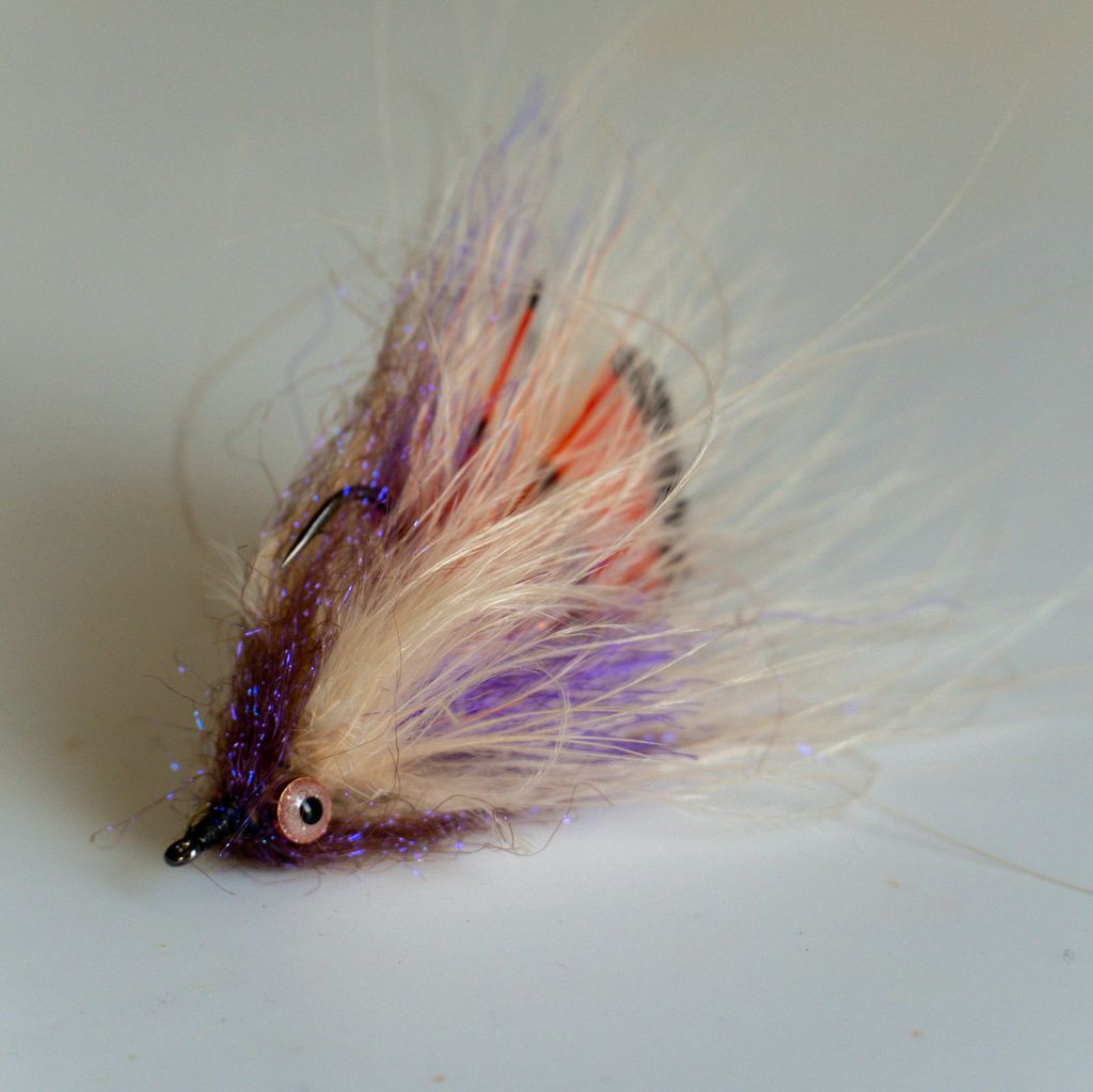 Purple, cream and orange streamer fly on a plain background