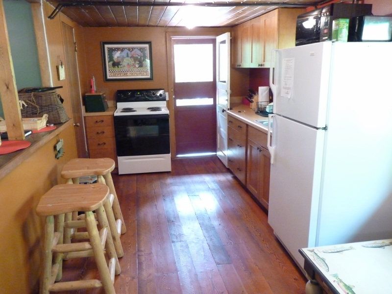 Cabin kitchen with a stove, refrigerator and wooden cabinets