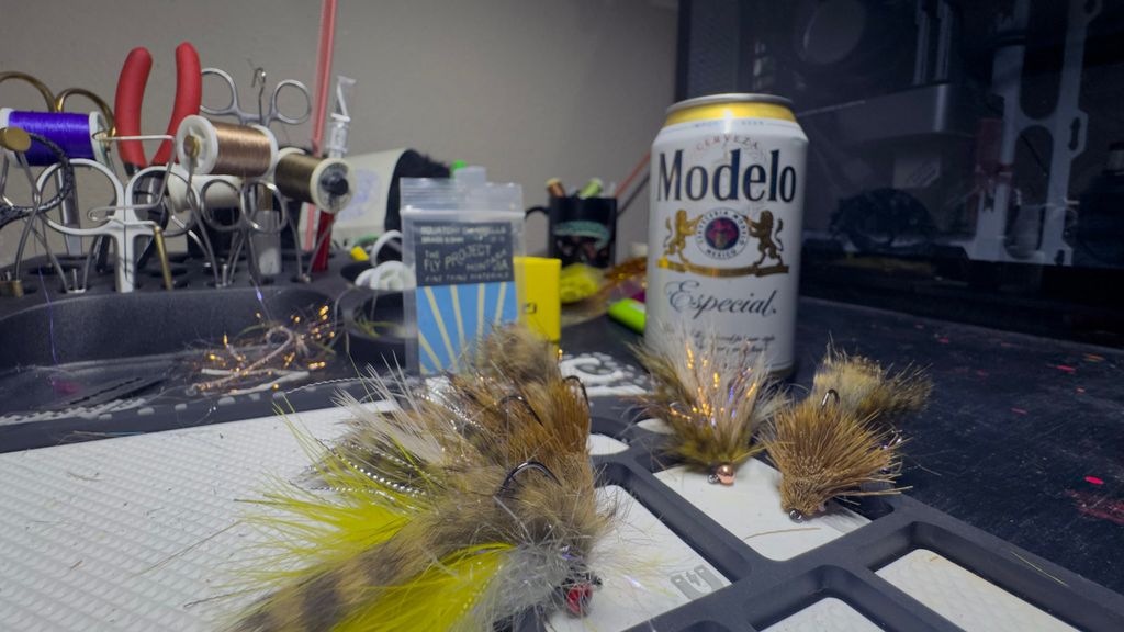 Finished streamer flies and tying supplies on the GFM workbench