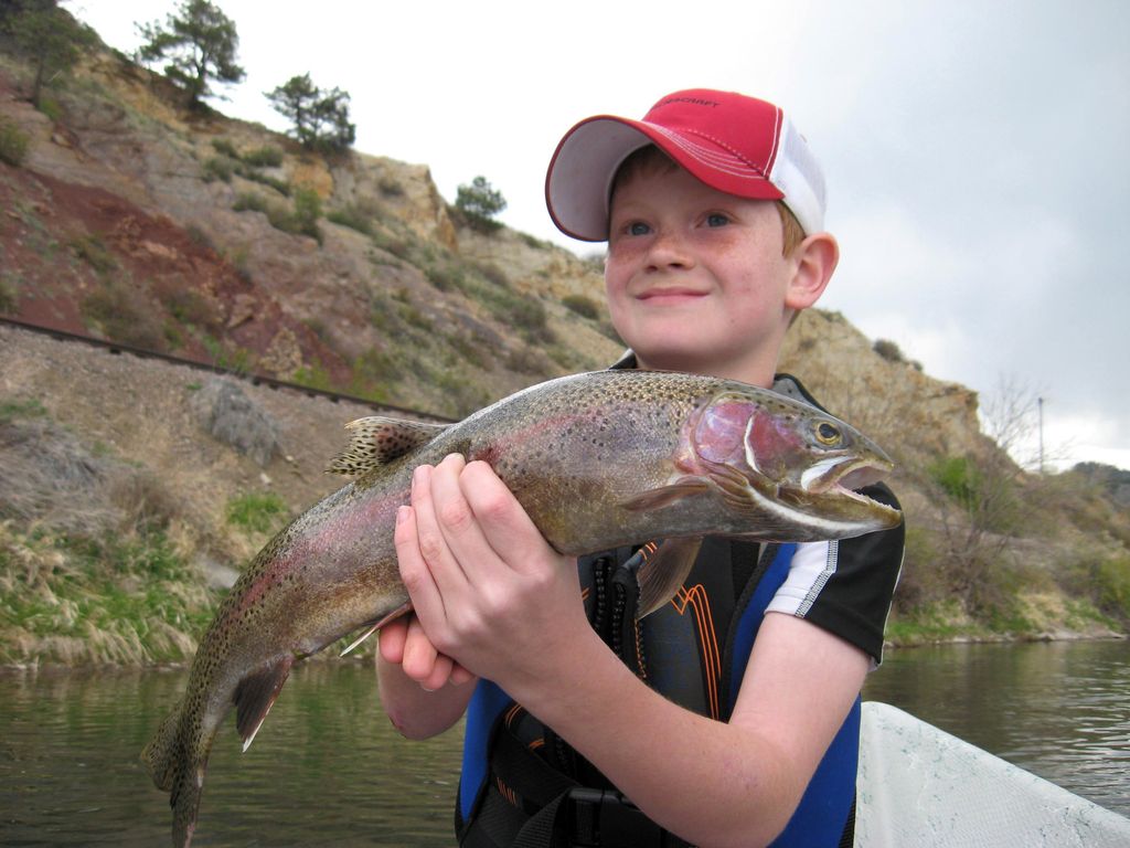 Young angler holding a trout beside the Missouri River