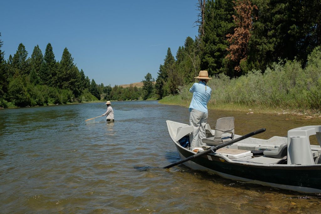 Angler casting from a drift boat on the Blackfoot River