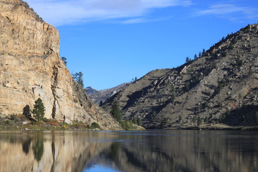 Rocky canyon walls reflected in calm water at Gates of the Mountains on Montana's Missouri River